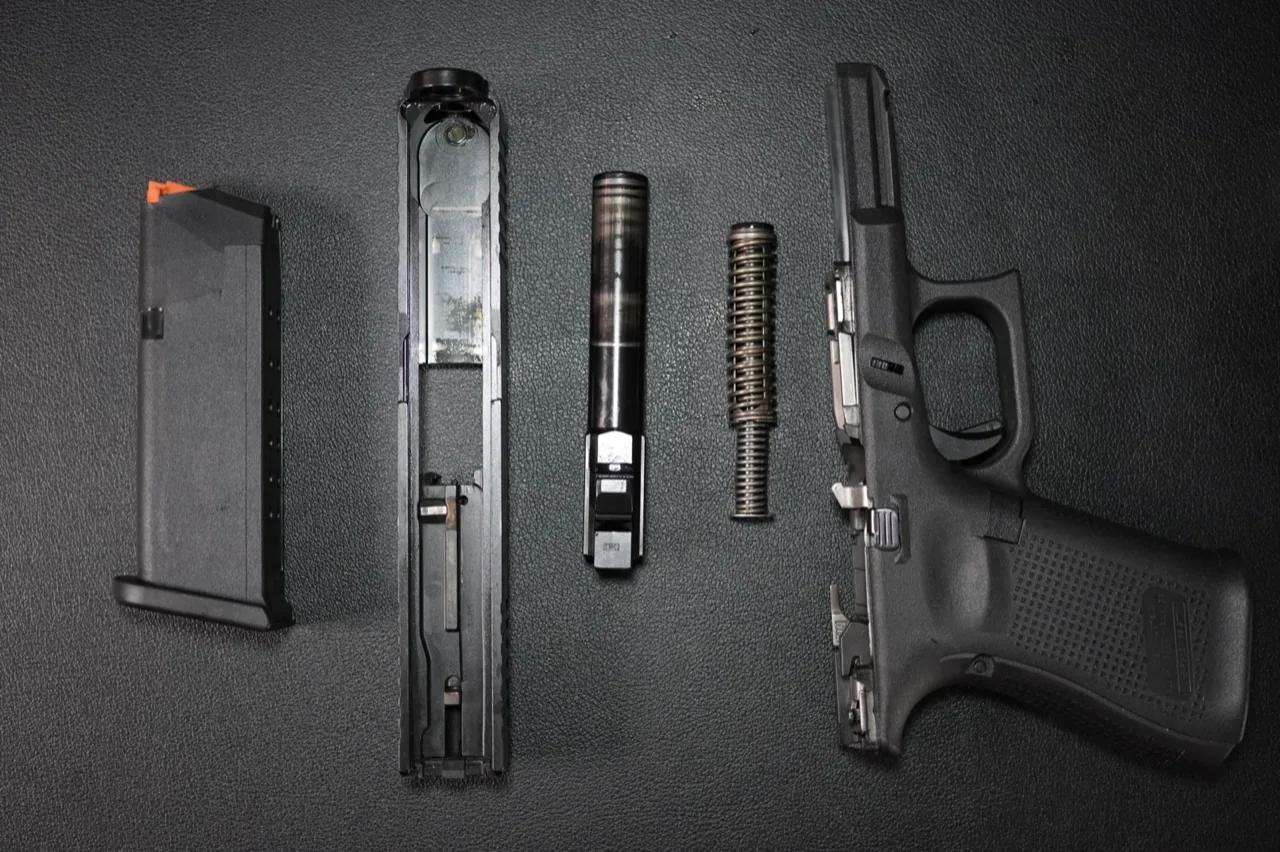 Glock 19 Gen 5 field stripped: magazine, slide, barrel, recoil spring assembly, and frame laid out