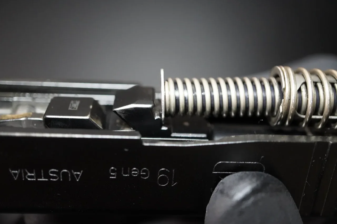 Recoil spring assembly seated in the second semi-circular notch on the Glock 19 barrel locking cams