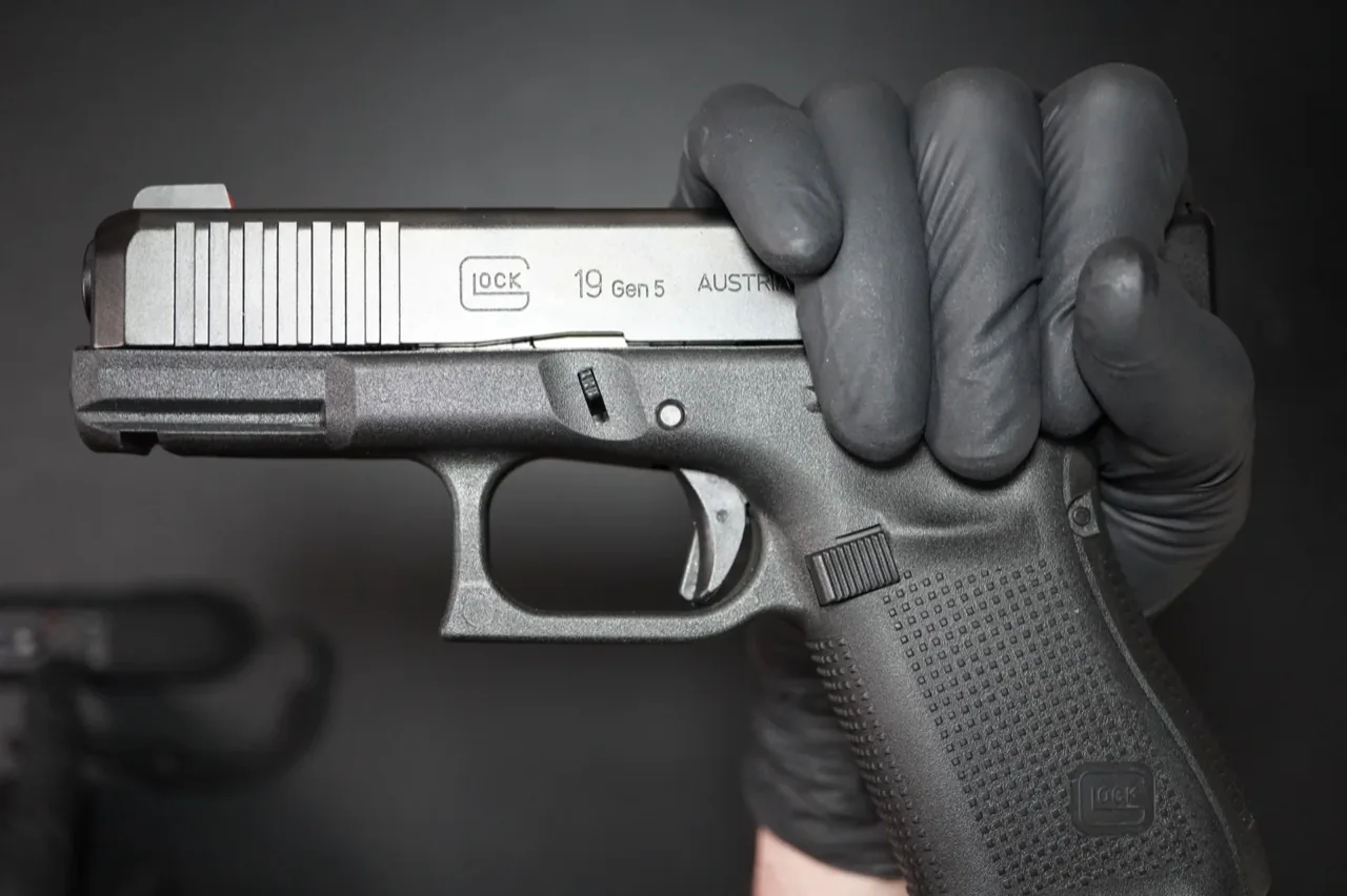 Firing-hand grip on the rear of a Glock 19 Gen 5 slide, ready for takedown