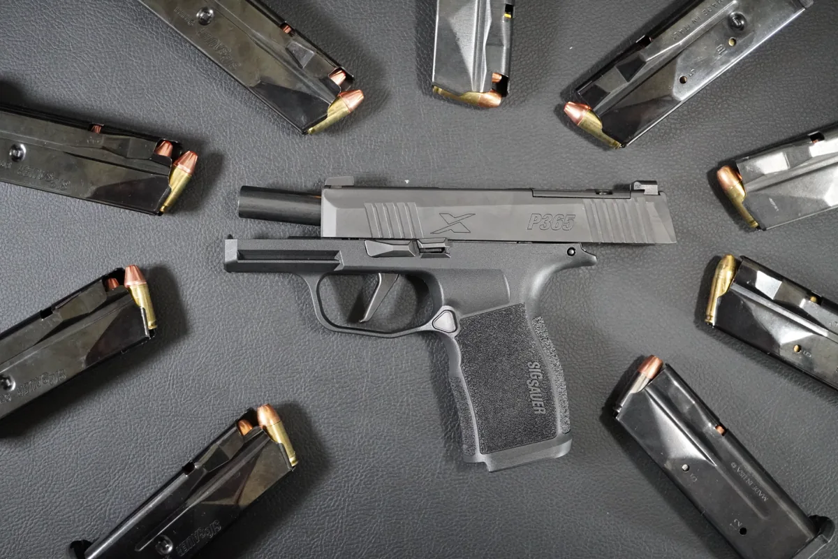 SIG P365X surrounded by loaded 9mm magazines
